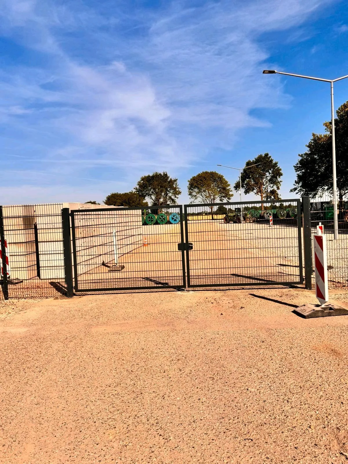 Doppelflügeltor aus Gittermatten als Zufahrt zu einem Schotterplatz
