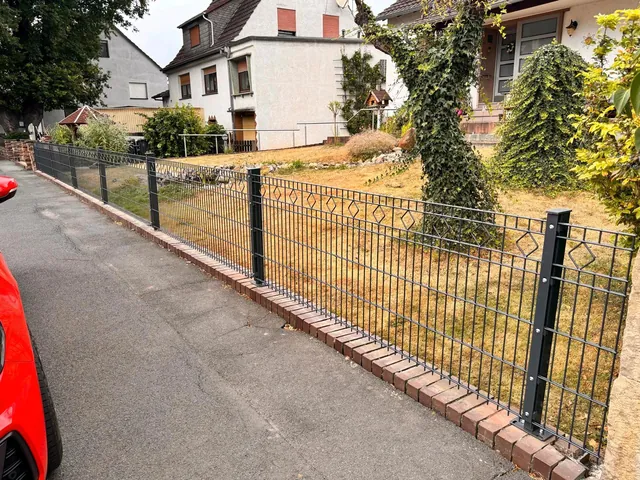 Doppelstabmattenzaun am Bürgersteig vor einem Wohnhaus